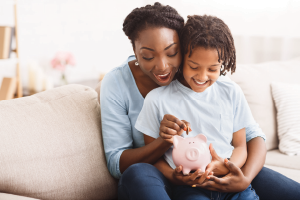 African American family inserting money into piggybank