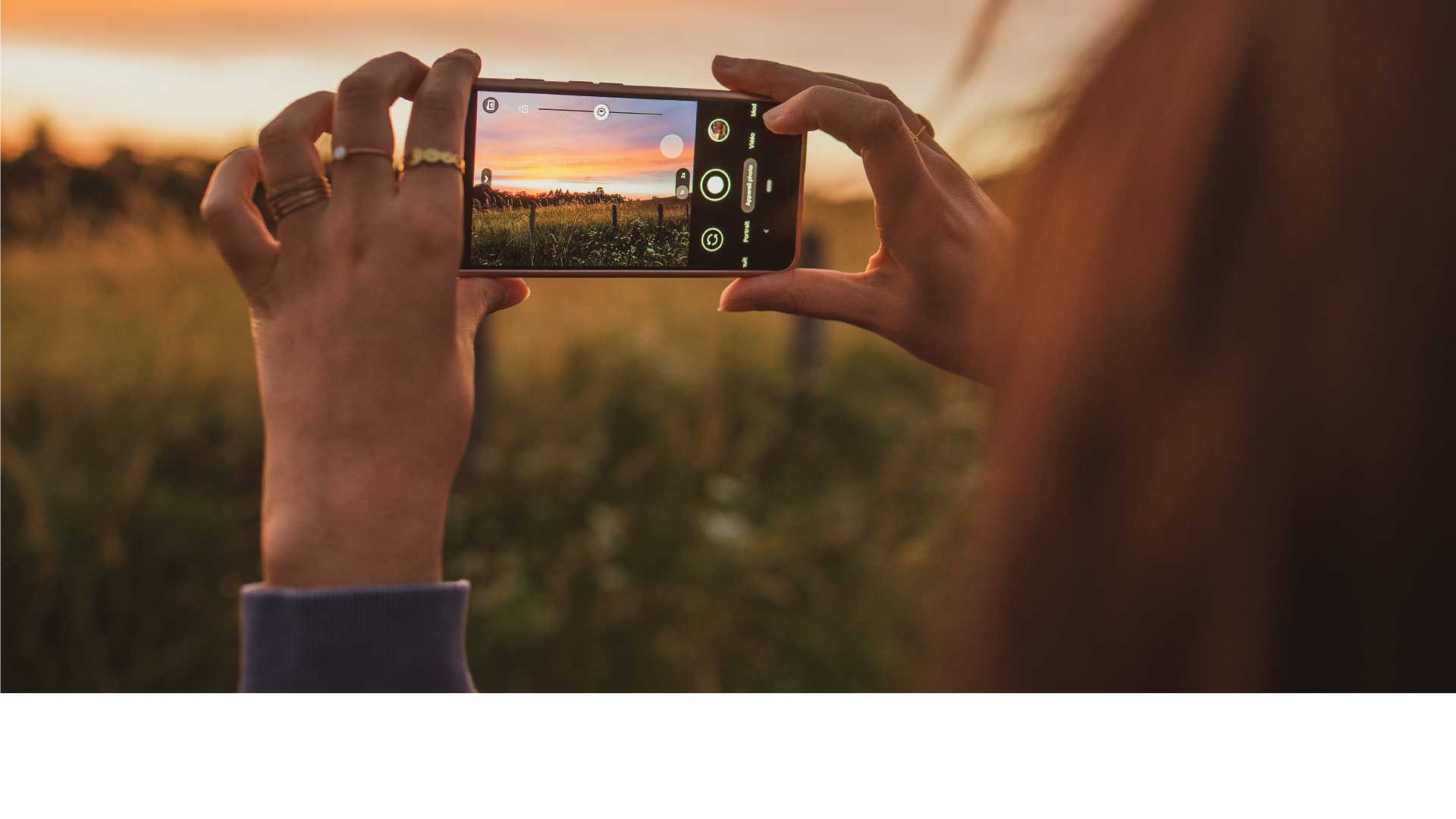Person taking pictures of a field at sunset