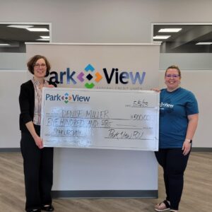 Denise Miller, 2023 Scholarship Winner, holds a giant, oversized check with Broadway Park View FCU Branch Manager Kristina Bontrager.
