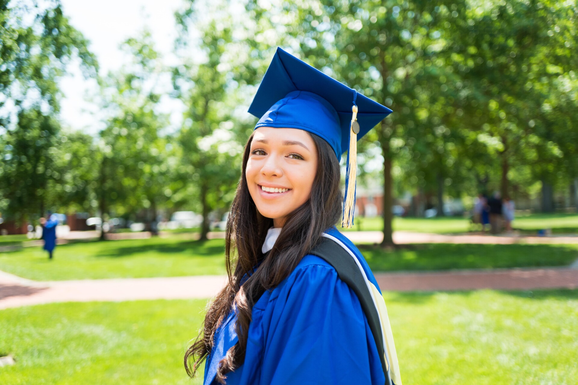 scholarship A young woman proudly wearing a graduation gown and cap, celebrating her academic achievement and scholarship with a bright smile.