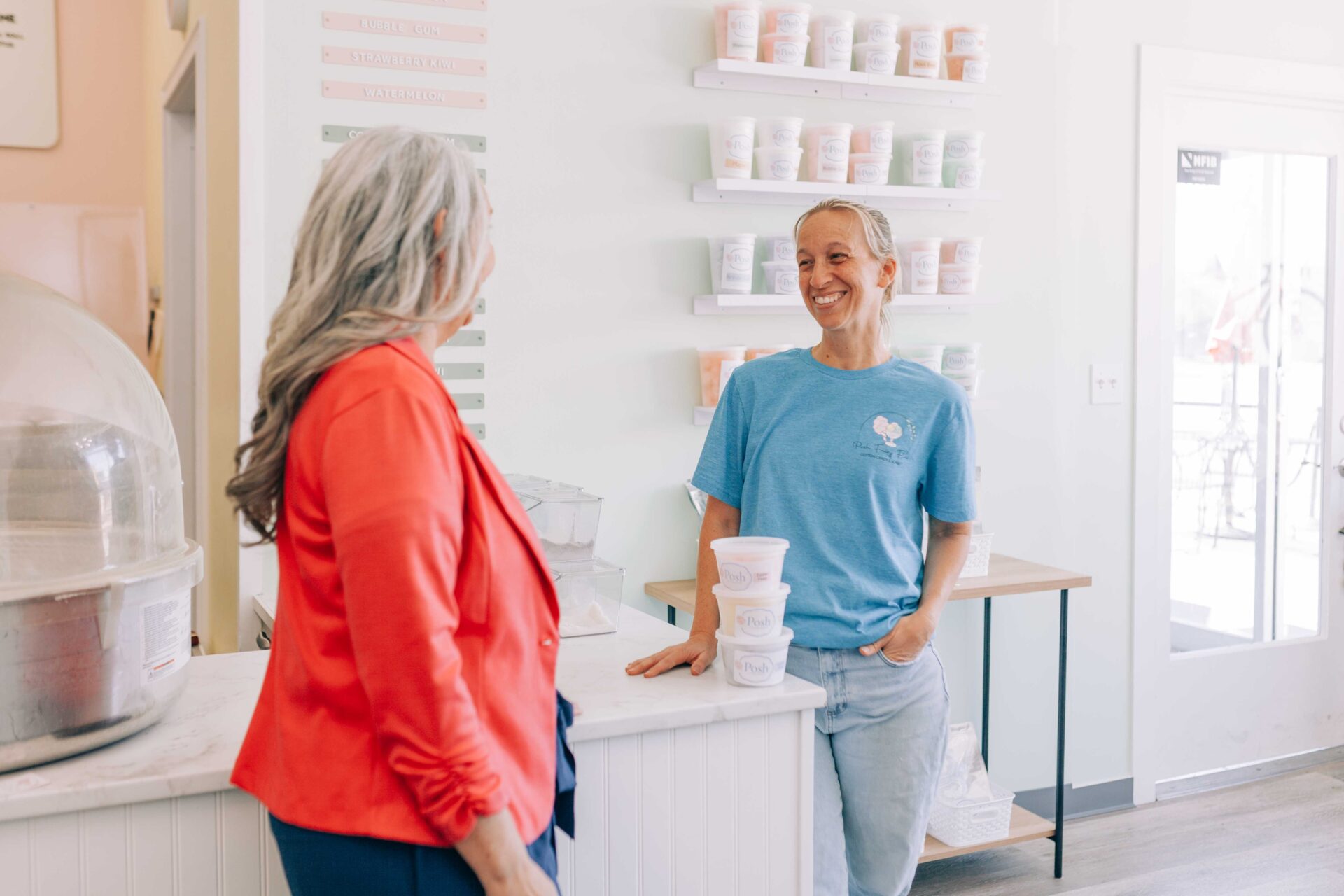 Two women in front of a shop counter, engaging in conversation about Park View and Posh Fairy Floss in Harrisonburg.