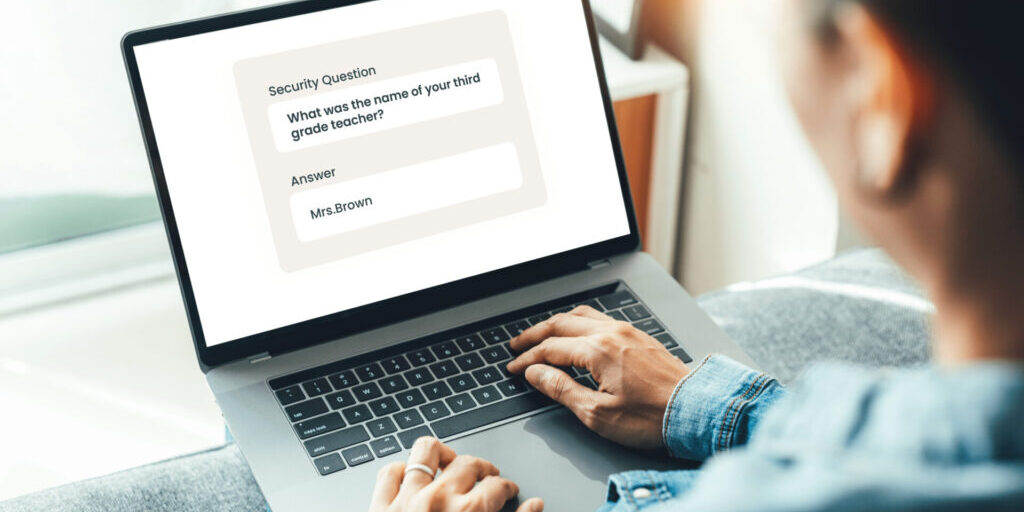 A person using a laptop enters "Mrs. Brown" as the answer to a security question asking for the name of their third grade teacher.
