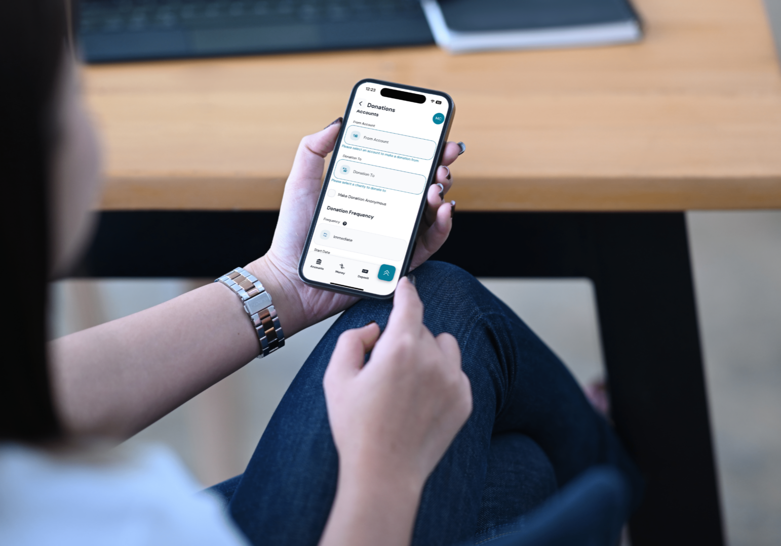 A woman uses her mobile phone to view her bank account, utilizing a donation tool for her charitable giving.