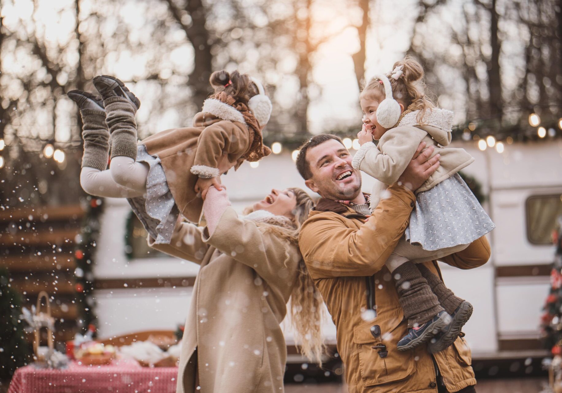 A joyful family playing together in the snow, building a snowman and enjoying the winter wonderland around them.
