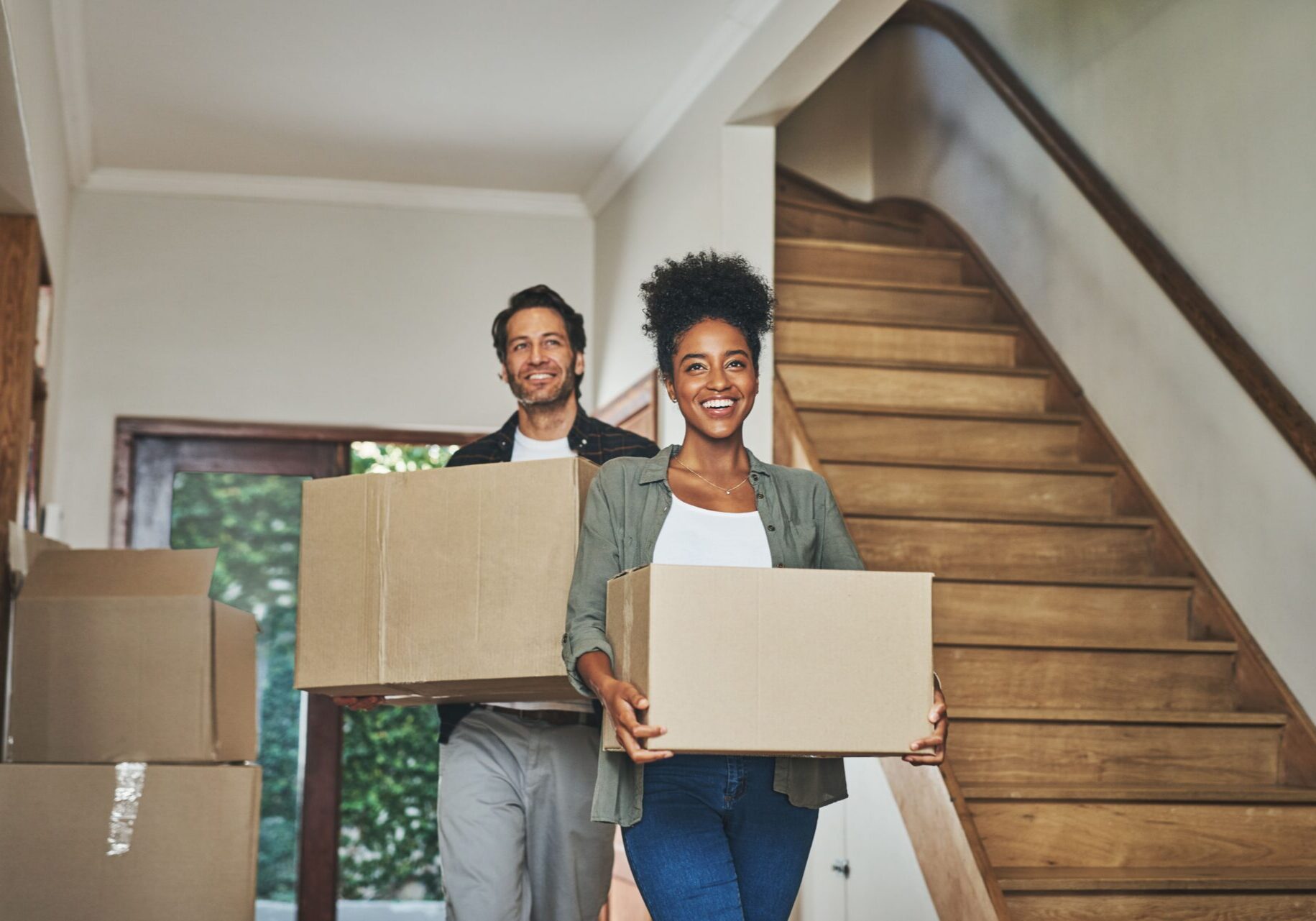 A couple moves boxes into their new home, excited about their fresh start with help for down payment and closing costs.
