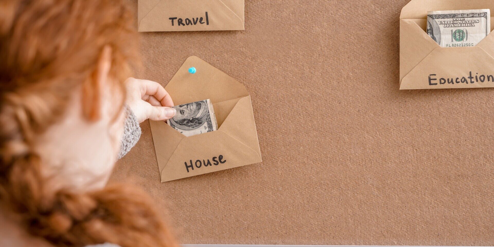 Woman putting money in envelopes for different needs. Concept of saving in a Club Savings Account.