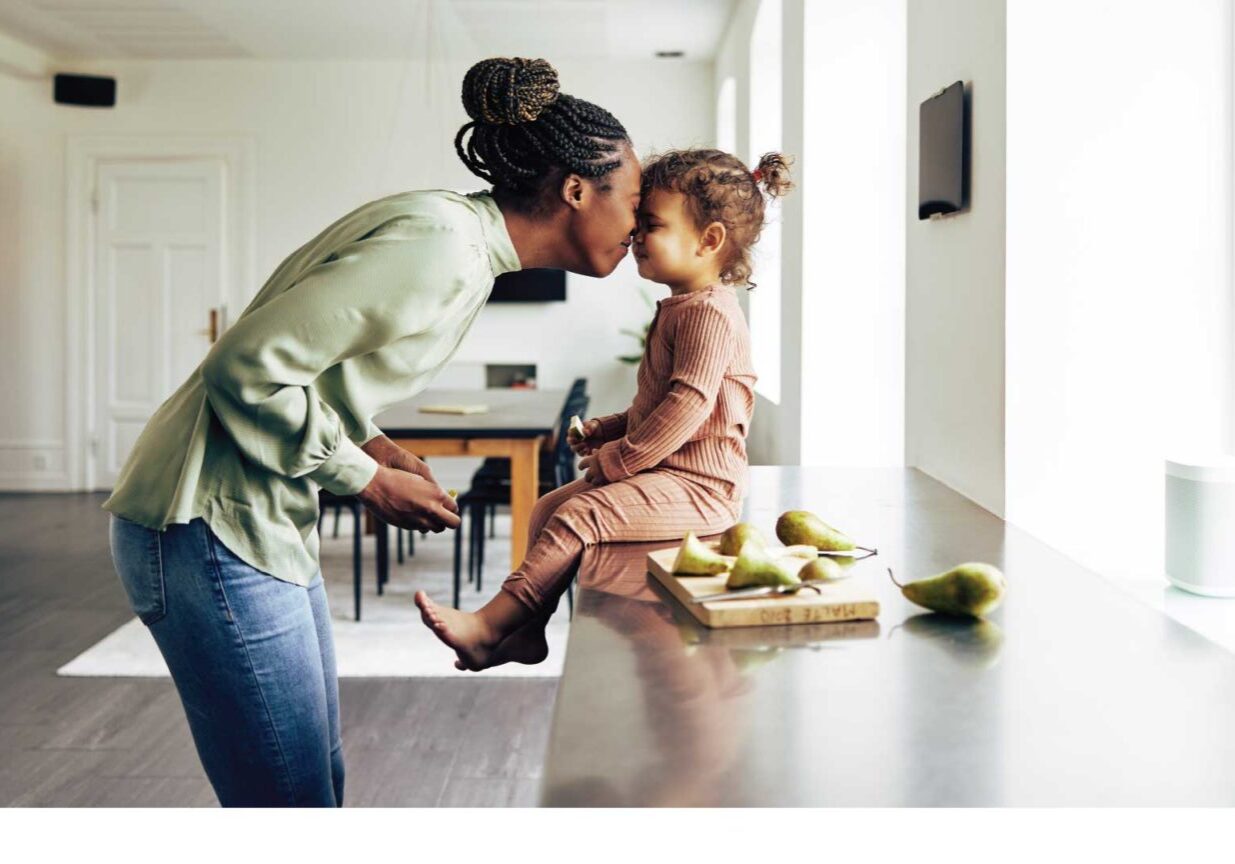 Image of a loving mom and her little girl having a snack at home. Home Mortgage Concept
