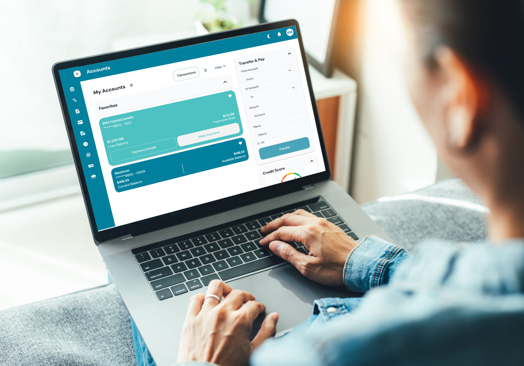 A woman sitting her couch, focused on her laptop while paying her Park View Federal Credit Union loan online.