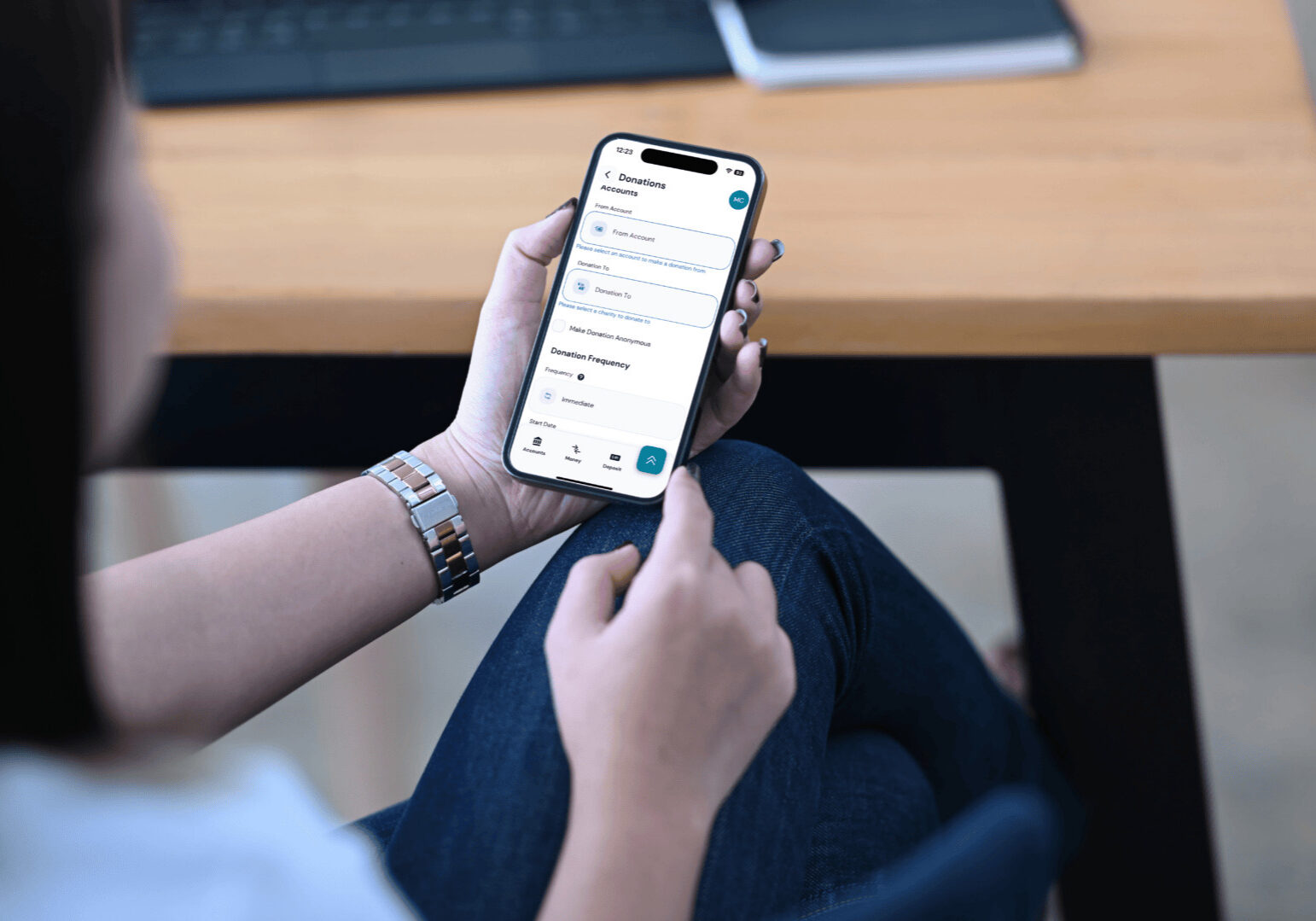 A woman uses her mobile phone to view her bank account, utilizing a donation tool for her charitable giving.