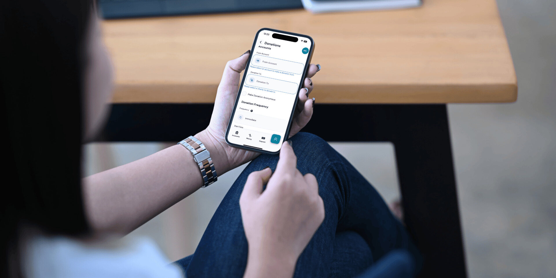 A woman uses her mobile phone to view her bank account, utilizing a donation tool for her charitable giving.